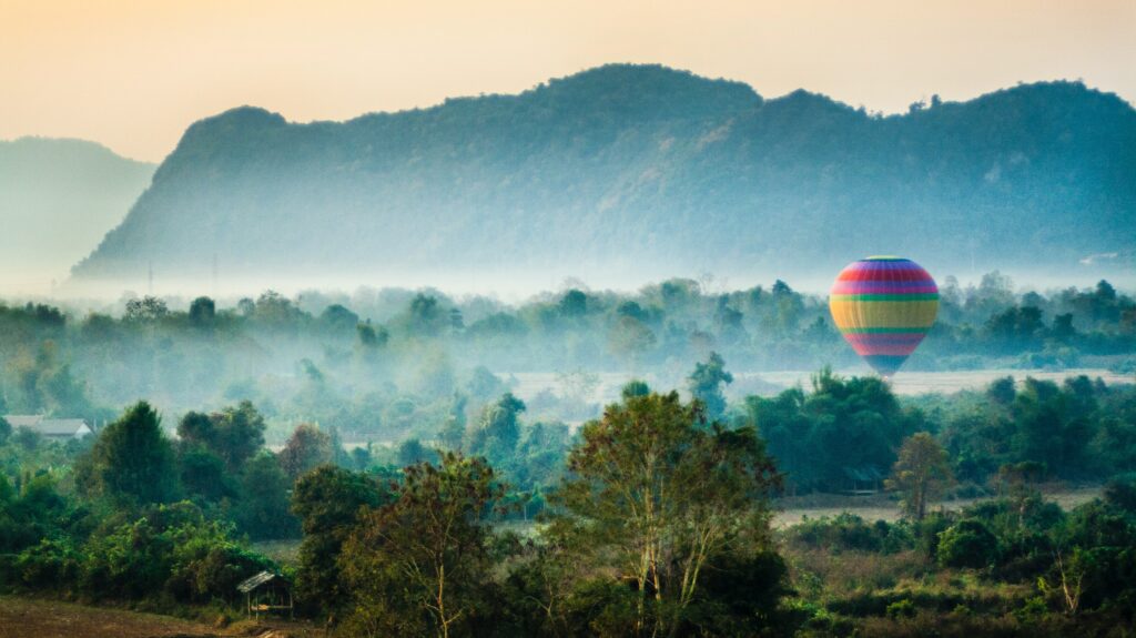 A hot air balloon flying over the limestone mountains of Vang Vieng